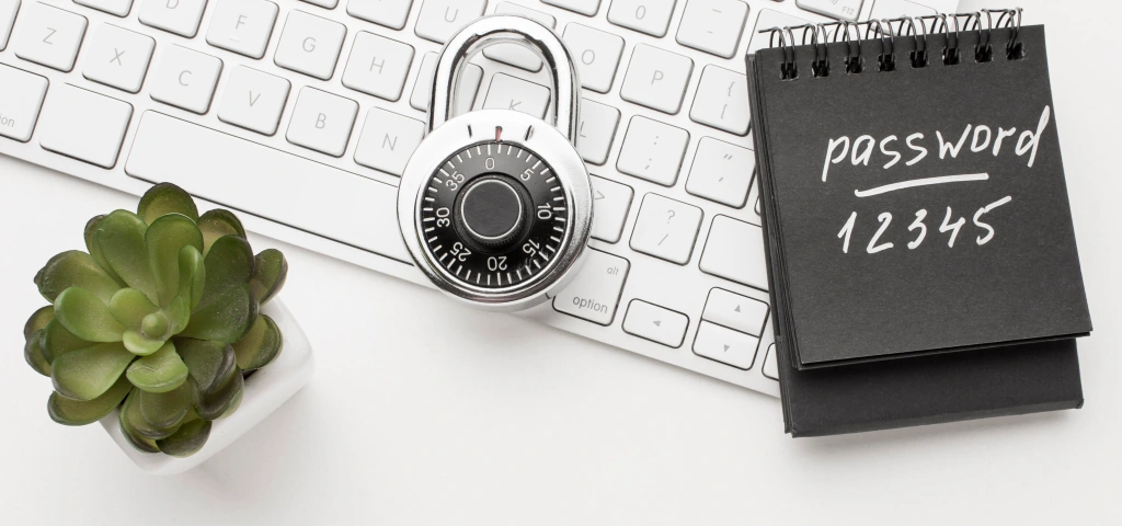 Candado sobre un teclado junto a un bloc de notas, símbolo del mantenimiento y la seguridad web
